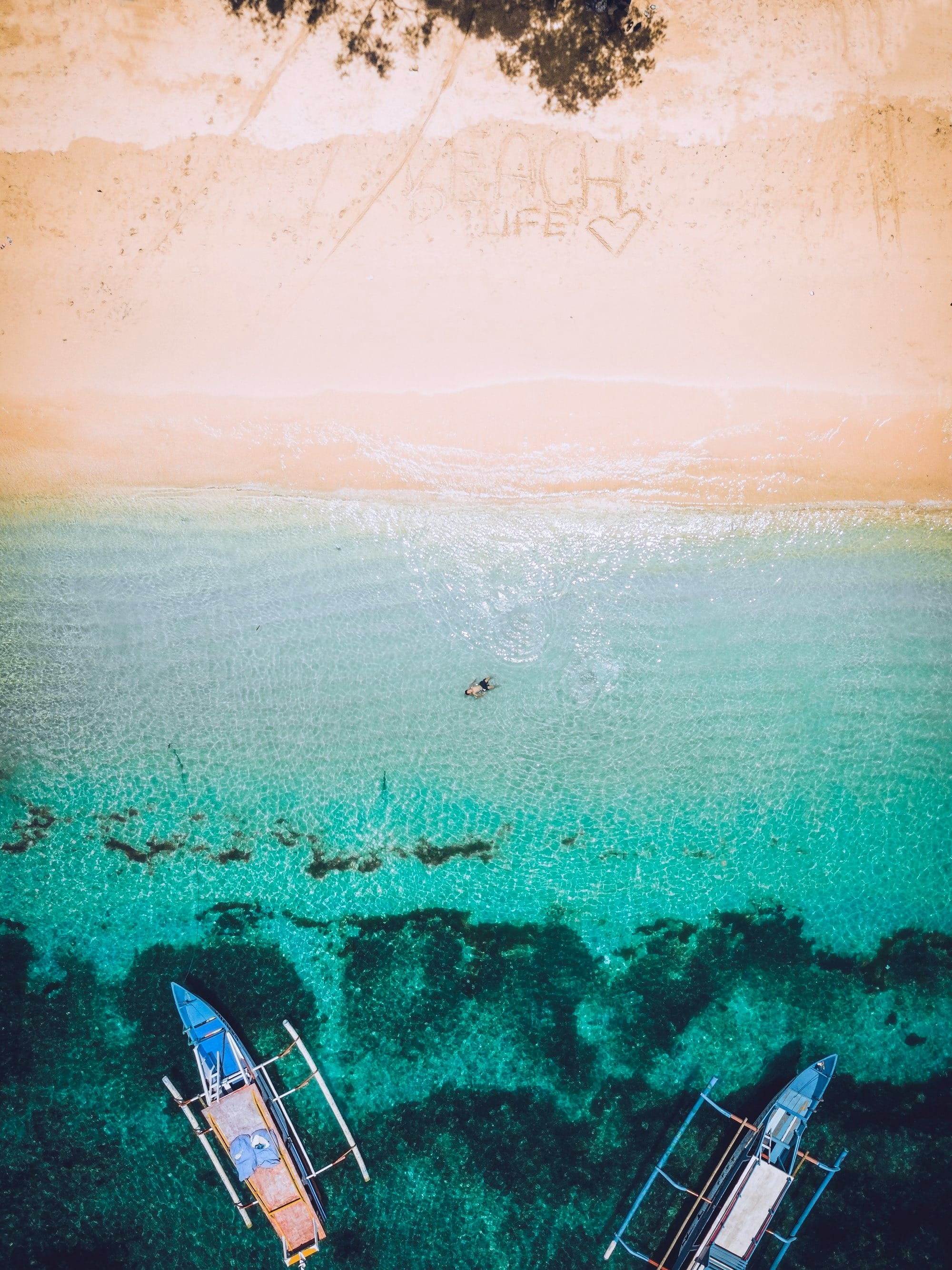 aerial photography of seashore with two boatd